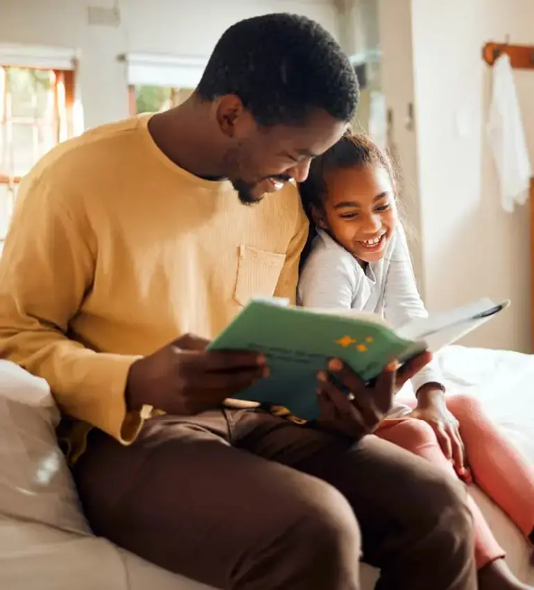 A father takes time to read his young daughter a bedtime story.