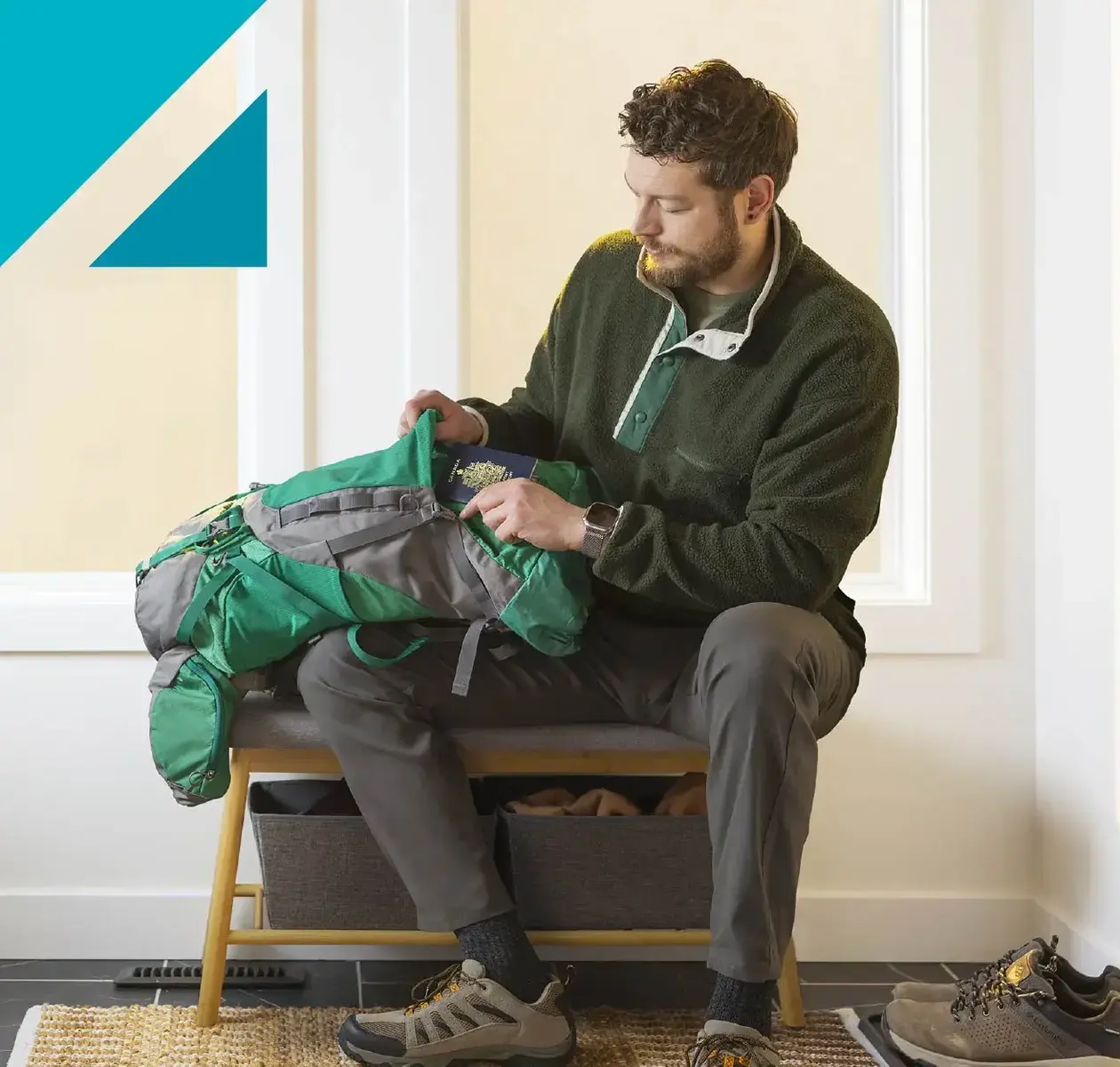 A young man preparing to travel packs his passport into a duffle bag.