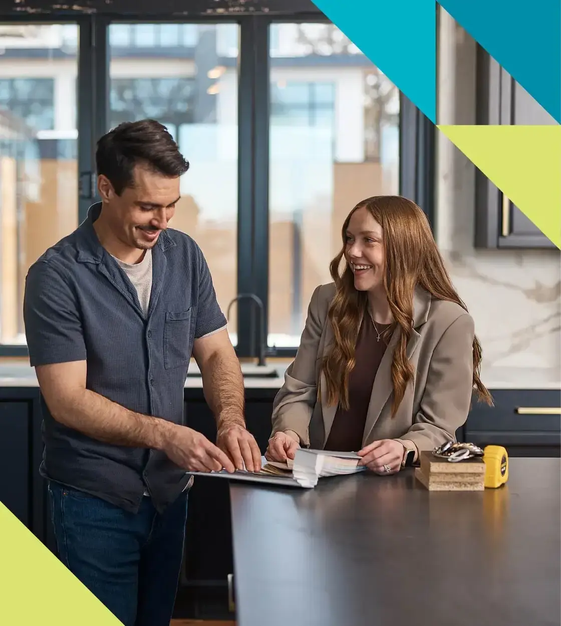 A man and woman excitedly explore colour options inside a new home build.