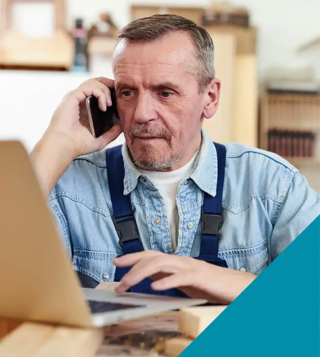 A man takes a break from carpentry work to discuss his business plans over the phone.