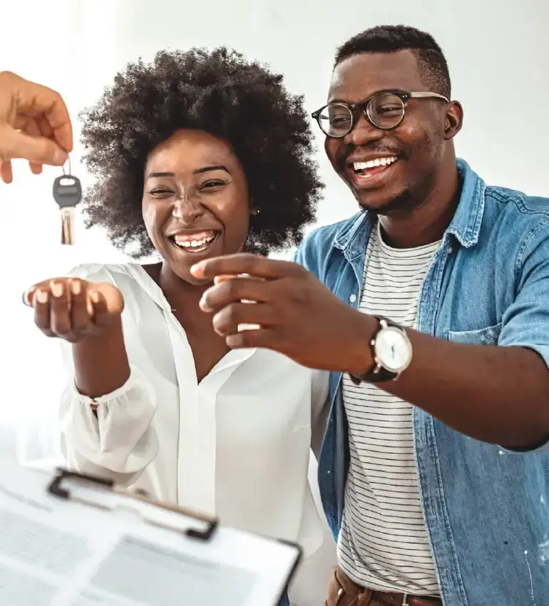 A happy couple receives the keys to their new home.
