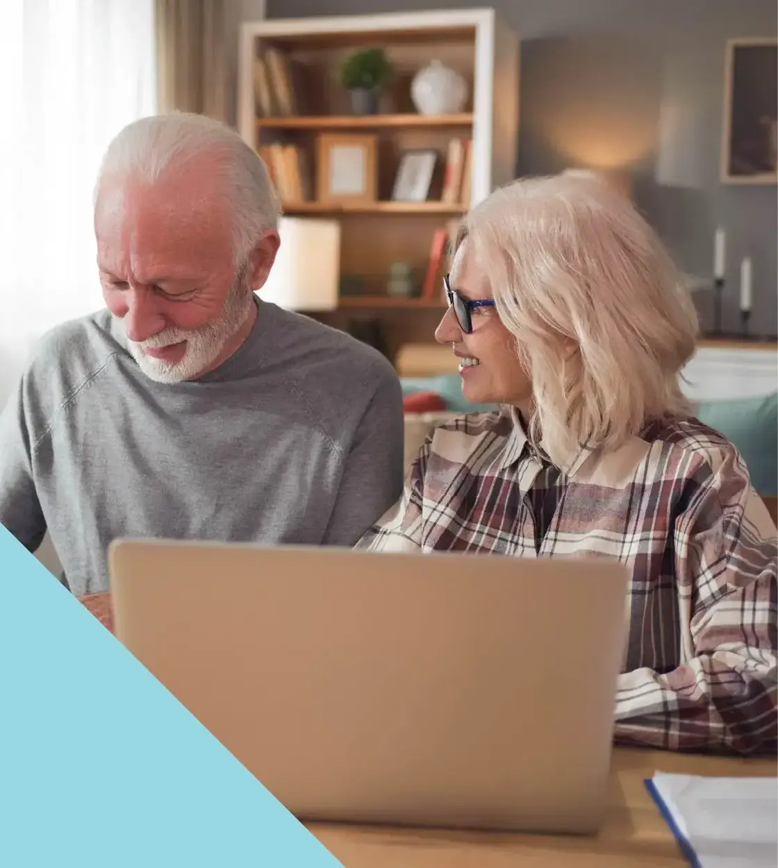 A husband and wife in their golden years take care of some business using their laptop computer.
