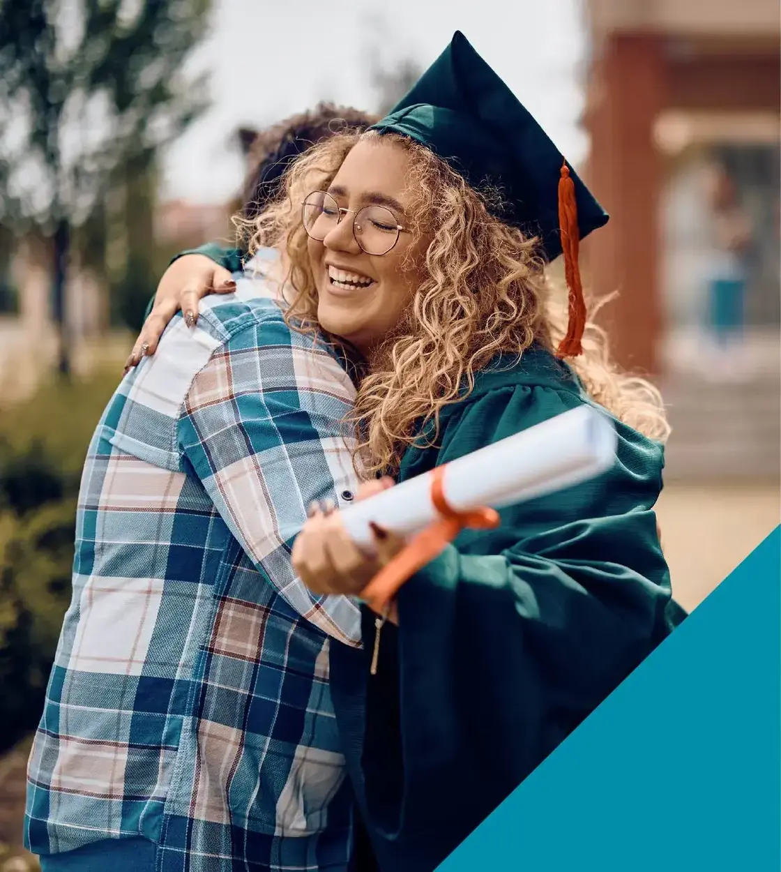 Donning a graduation cap and gown, a young woman receives a big hug on her day of celebration.