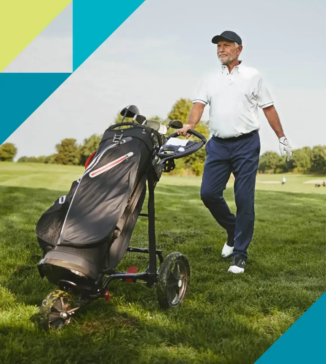 A man on a golf course walks towards his ball with his clubs in tow.