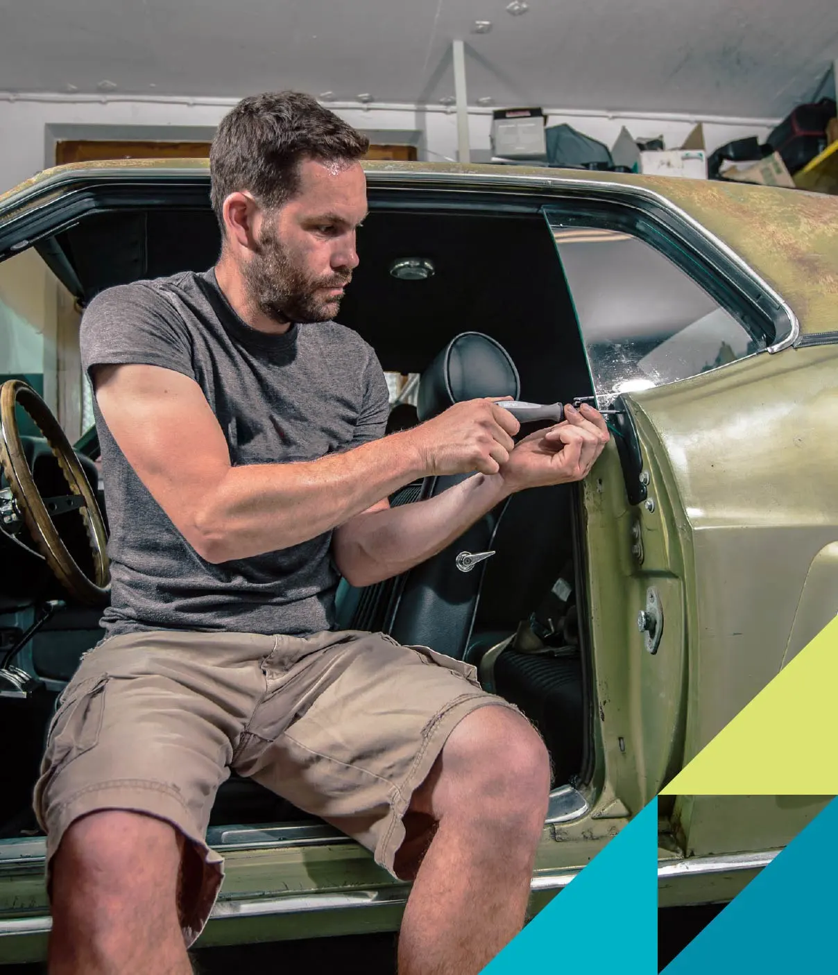 A man wearing a grey t-shirt and cargo shorts does some needed repairs to his car door.