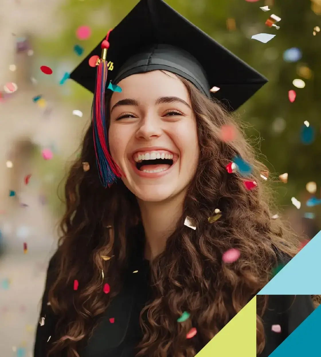A young woman in a graduation cap and gown smiles while confetti falls around her.