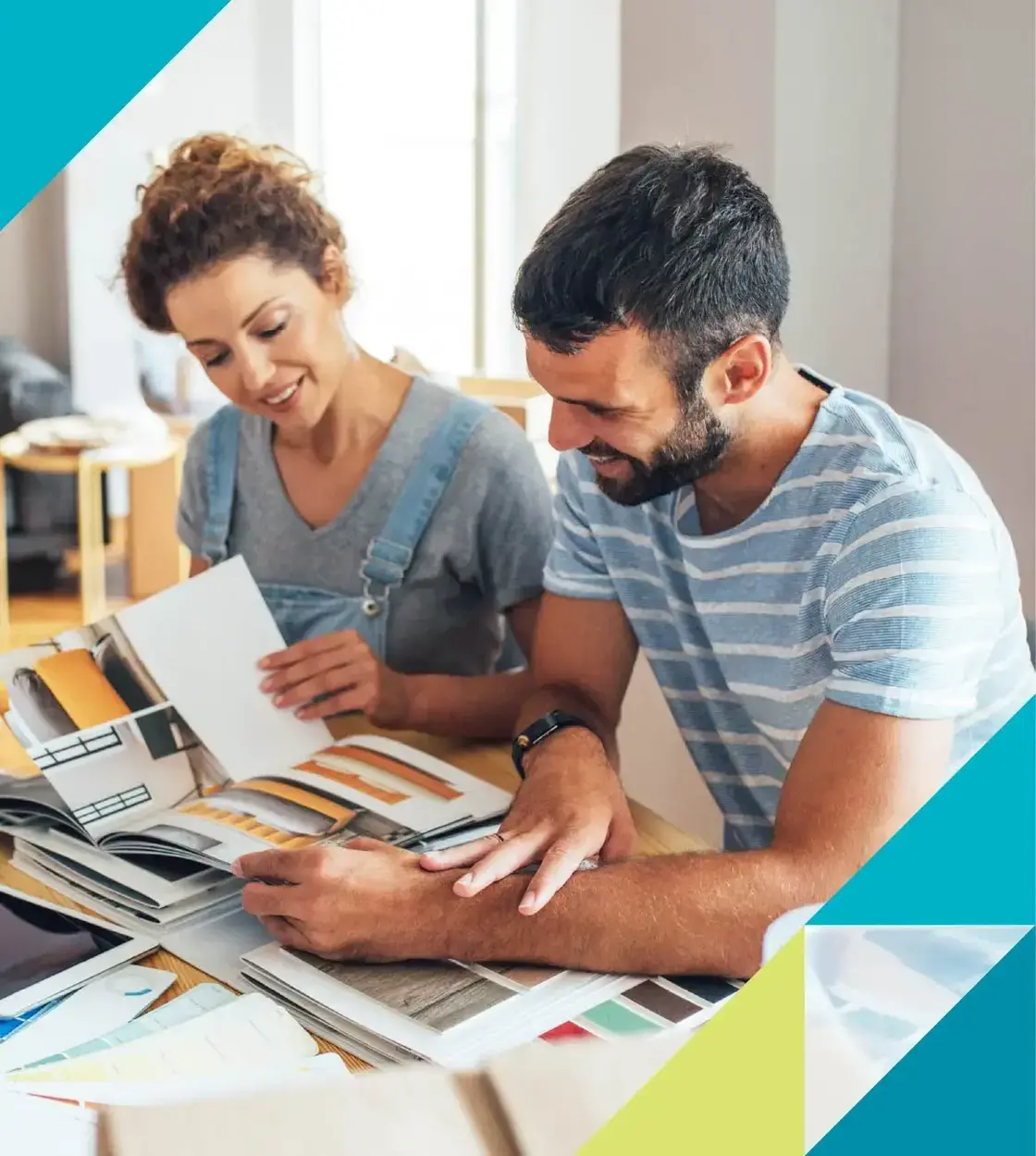 A man and woman explore interior design options on a kitchen table.