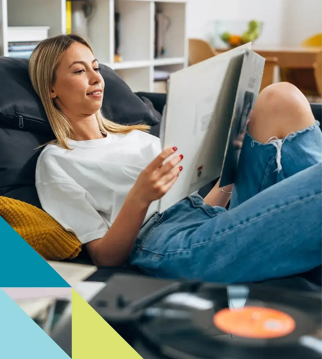 Dressed in jeans and a t-shirt, a young woman kicks back and listens to some classic vinyl records.