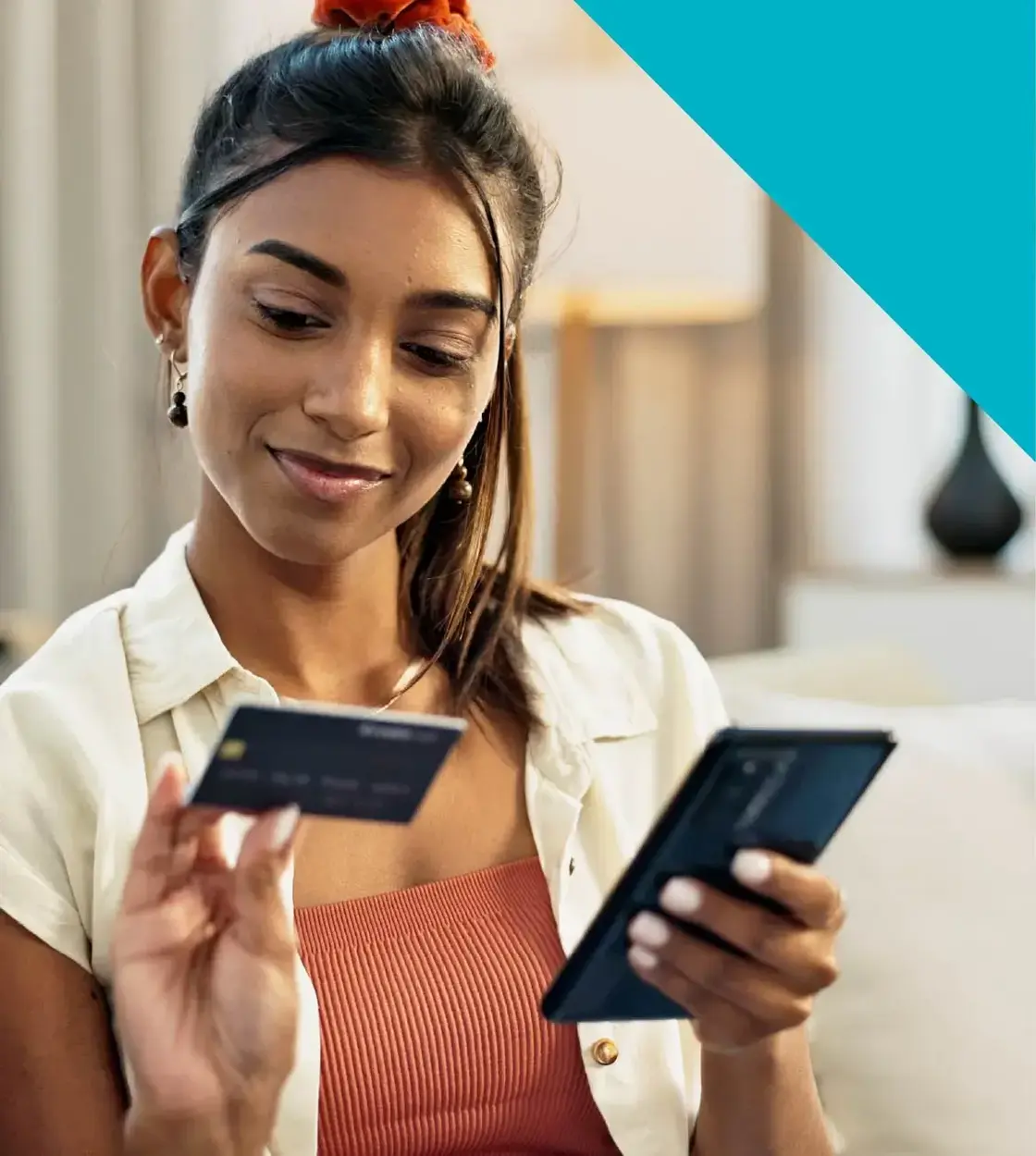 A young woman with long brown hair does some online banking using her mobile phone.