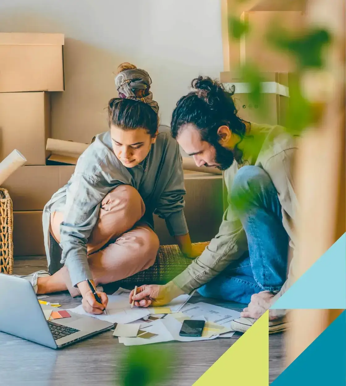 Surrounded by moving boxes, a young couple mockup the perfect layout plan for their new home.