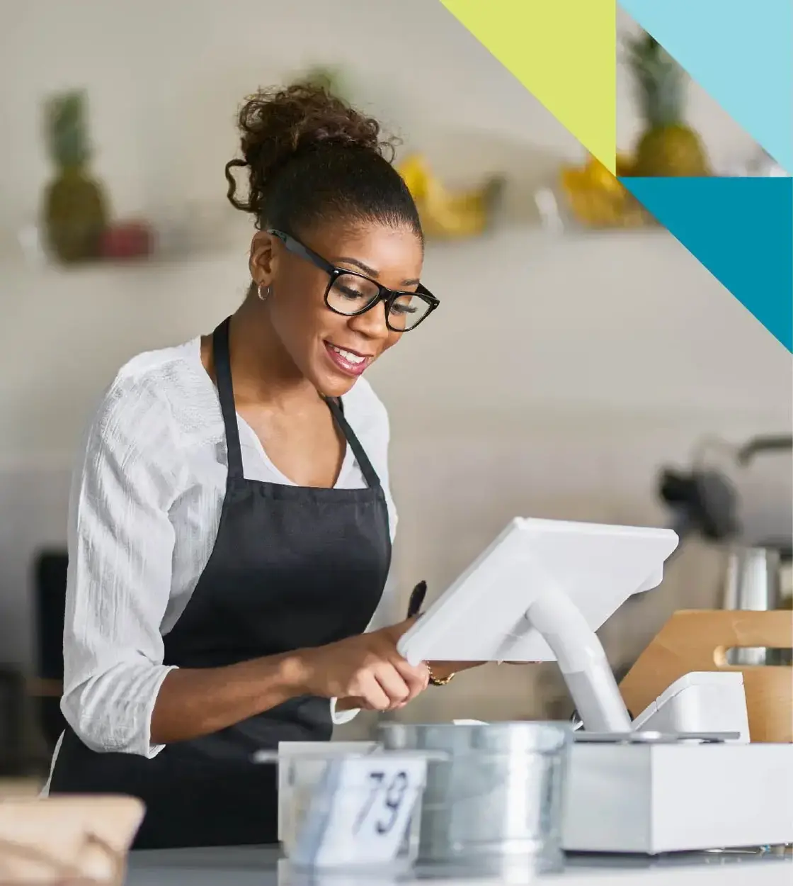 A woman wearing glasses and an apron enters an order into her work’s point of sale system.