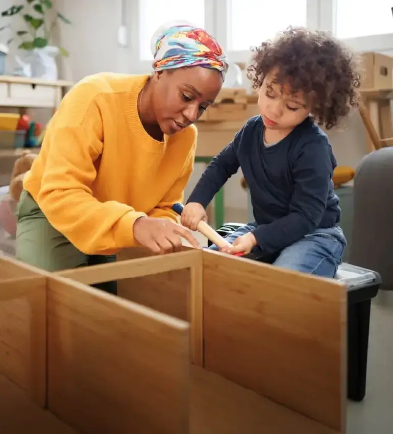 A mother and her young child hammer out a fun construction project together at home.