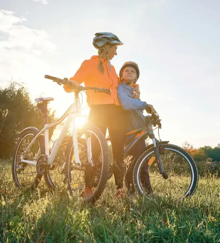 A mother and child take a break from cycling to bask in the sun’s fading light.