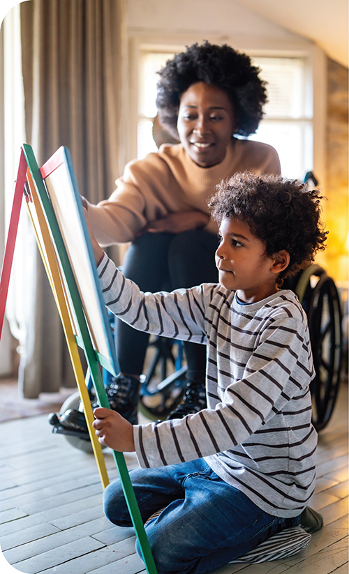 Mom in a wheelchair helping her son draw